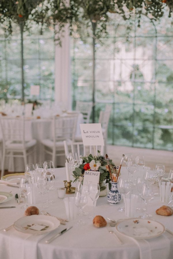 Une vue rapprochée des bouquets de fleurs et des décorations sur la table des mariés pour Carole et Ali.