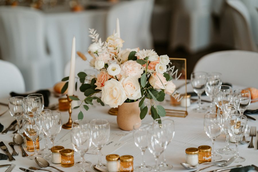 Une table de réception ornée de superbes compositions florales au mariage de Siobhan et Thibault.